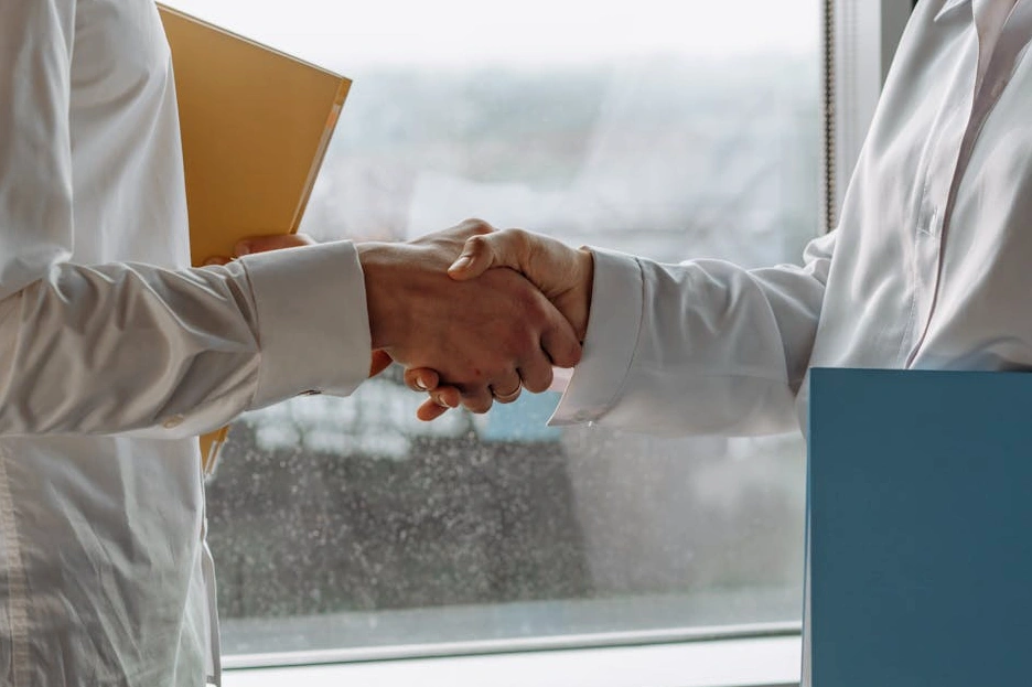 Consulente che stringe la mano a un cliente in un moderno ufficio.